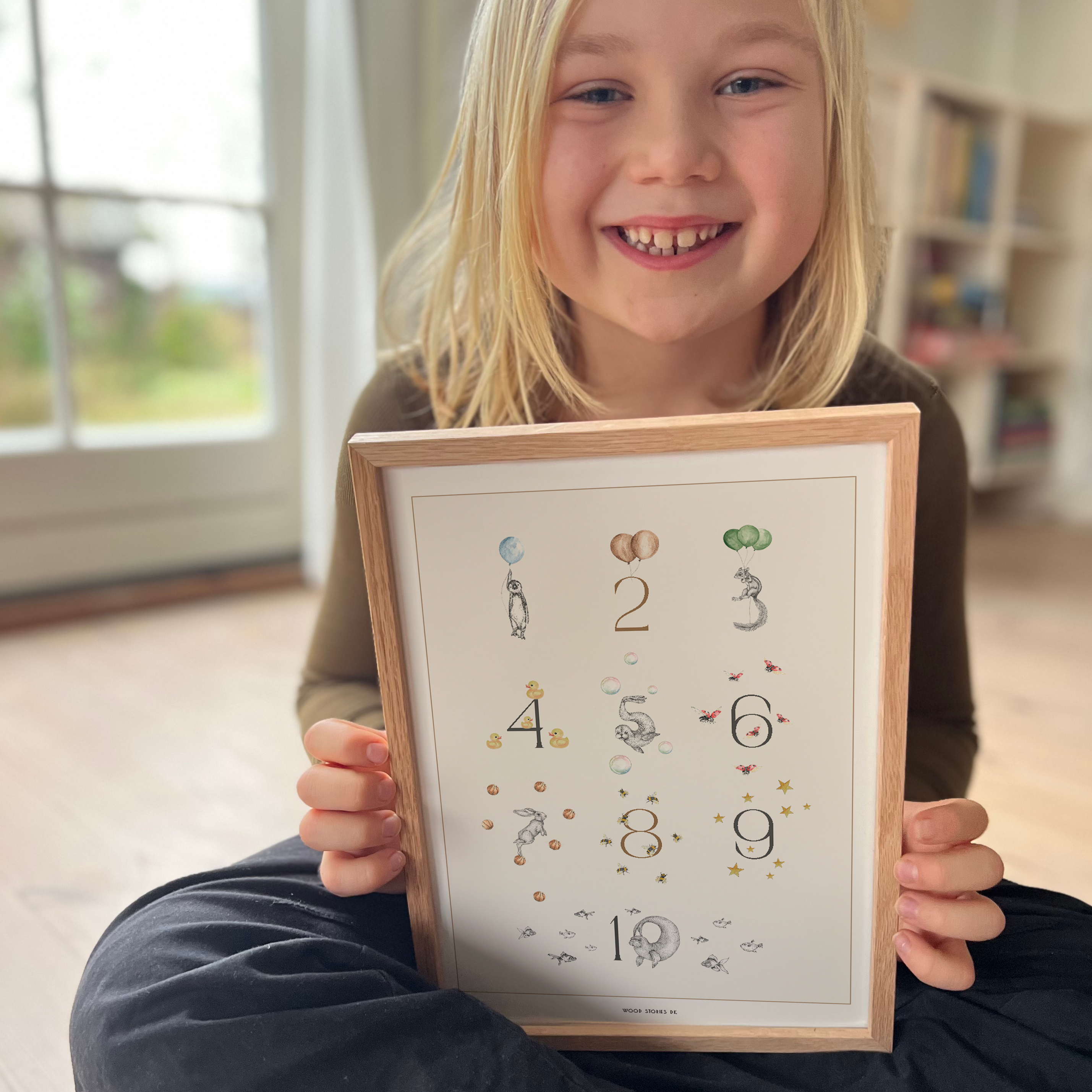 Barn holder børneplakat med tal og illustrationer til læring