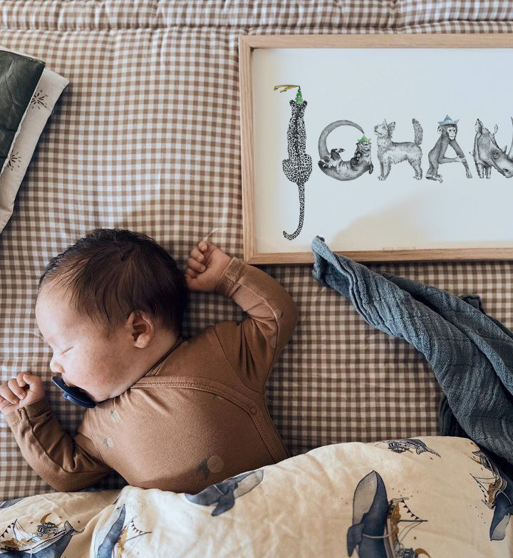 Personlig navneplakat med navnet Johan sammen med sovende baby